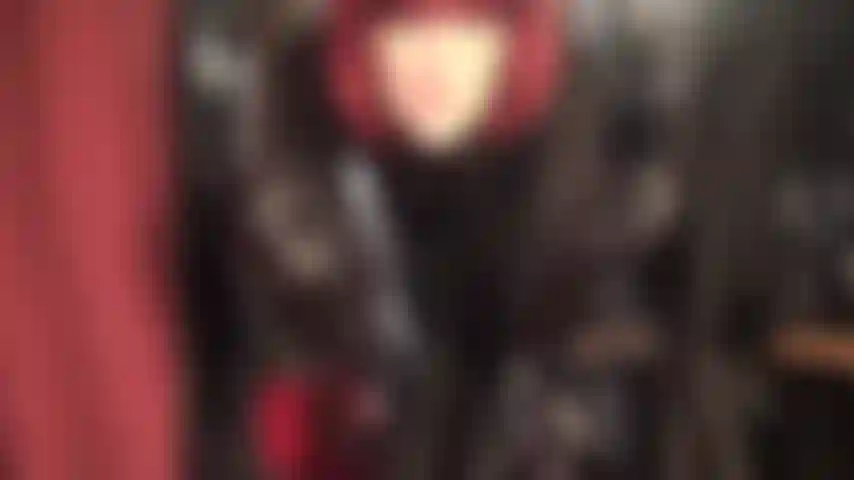 Herrin, die einen eleganten schwarzen lederrock, eine satinbluse, schnürstiefel und lange lederhandschuhe trägt und mit den wunderbaren seidigen strumpfhosenbeinen darunter neckisch wirkt.