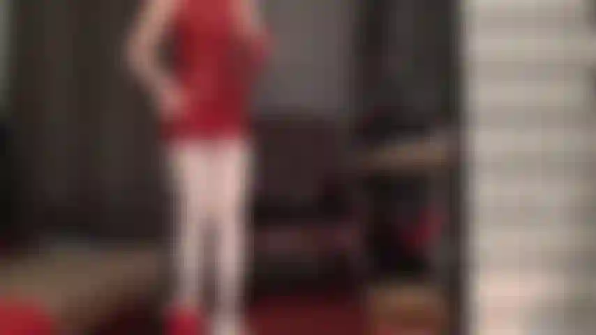 Rotes latex passt gut zu weißen strumpfhosen – die herrin trägt ein knappes rotes gummi-minikleid und glänzende weiße strumpfhosen. Dazu trägt sie schulterlange latexhandschuhe und einen winzigen roten tanga für verführerische upskirt-blicke.