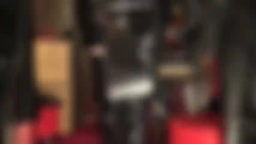 Eine fetisch-herrin aus glänzendem lack mit reitgerte und overknee-stiefeln.