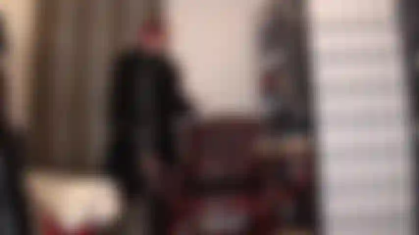 Eine pelzliebhaberin – hier ist ein wunderbarer stoffmix, herrin ganz in schwarz gekleidet, glänzendes lackkleid, lederhandschuhe und langer pelzmantel, beine in schwarzen strumpfhosen und kniestiefeln.