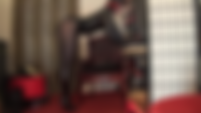 Eine göttin aus glänzendem pvc – diesem fetisch-outfit können sie nicht widerstehen. Von kopf bis fuß glänzend in schwarzem vinyl, kniestiefeln und mehreren schwarzen strumpfhosen.