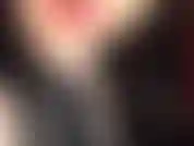 Latex-dekolleté-tease – die herrin neckt und verführt mit einem sexy dekolleté, indem sie den reißverschluss ihres engen, glänzenden schwarzen latex-outfits herunterlässt.