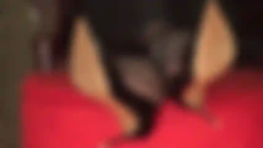 Baumle und spiele mit schuhen, mit gekreuzten knöcheln und füßen auf dem ottomanen.