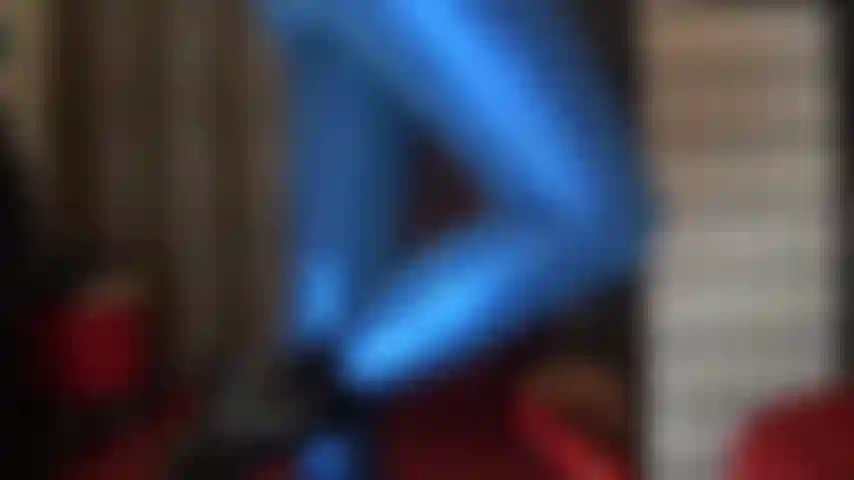 Mit langen beinen und sexy hintern in glänzenden, metallisch blauen leggings.