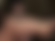 Herrin benutzt ihre geschmierten, glänzenden nackten füße, um einen schwarzen dildo zu streicheln.