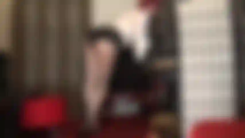 Die den beinliebhaber in hübschen grau-silbernen glanzstrumpfhosen und pantoletten mit hohen absätzen neckt.