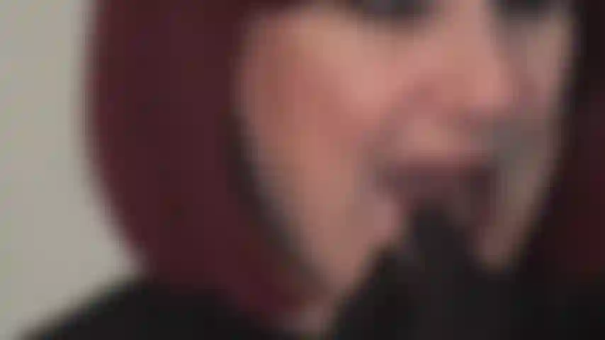 Glänzende rote lippen lassen sie auf die knie fallen – herrin trägt roten lippenstift auf und neckt mit ihrem verführerischen mund, während sie sich langsam die lippen leckt.