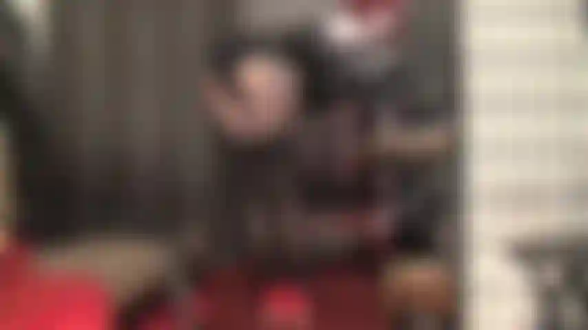 Herrin streichelt sanft den schwanz ihres sklaven mit langen lederhandschuhen, während sie mit ihren schichten schwarzer strapsstrümpfe über strumpfhosen und heißen shorts neckt.