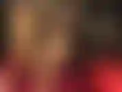 Ein heißer fetischist mit überkreuzten beinen in einem hautfarbenen nylon-bodystocking, gepaart mit metall-stilettos und sexy handschuhen.