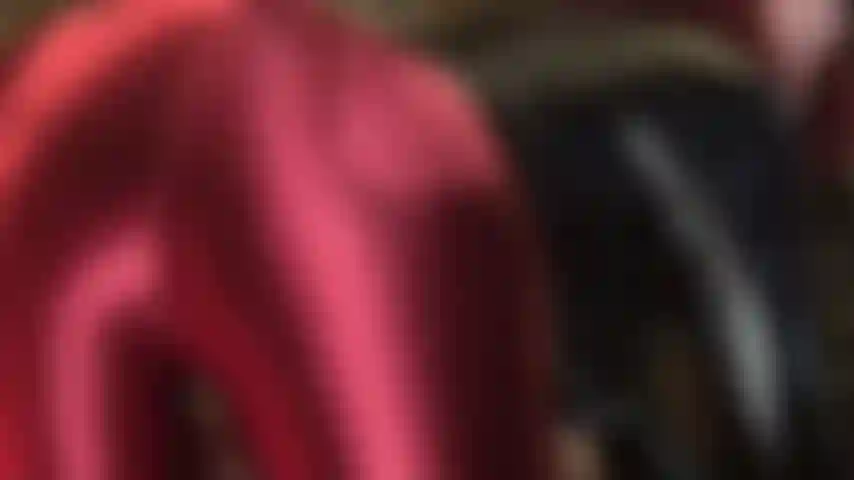 Die ihren arsch verehrt, in einer glänzenden satinhose in burgunderrot.