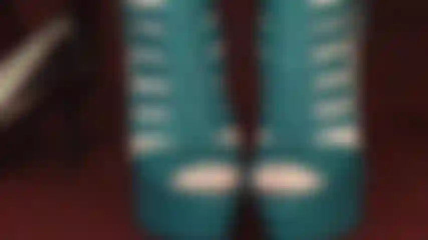 Die zehen verehrt, in hauchdünnen weißen strumpfhosen und blaugrünen peeptoe-stiefeln mit schnürung.