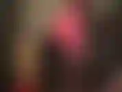 Herrin zeigt ihre erstaunlichen kurven und ihren fitten körper in einer bluse und hose aus seidigem satin sowie lederjeans.