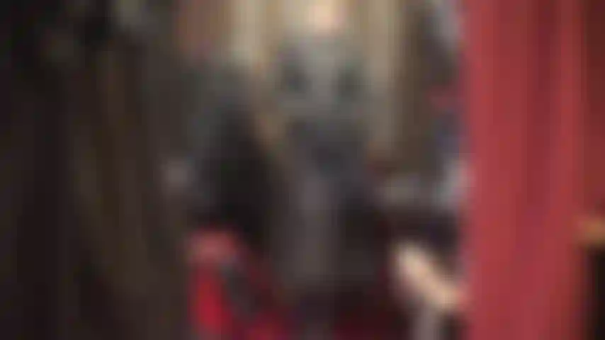 Eine anbetungsherrin in einem wunderschönen langen ledermantel, hohen stiefeln und handschuhen.