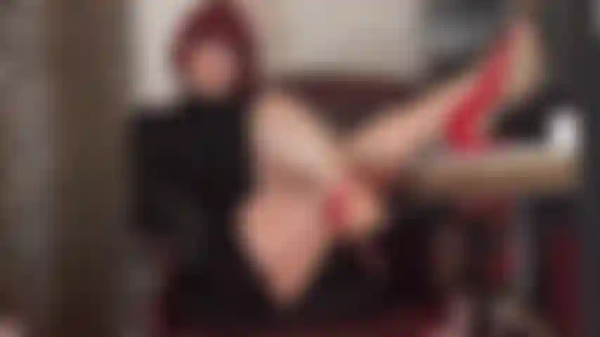 Eine sexy chefin, deren beine und absätze in glänzenden langen strumpfhosen auf ihrem schreibtisch liegen.