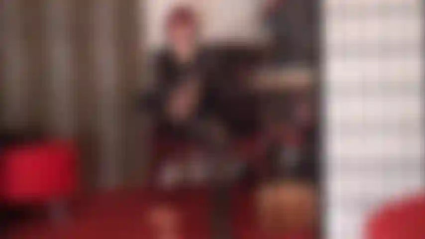 Die ihrem fußfetisch frönt, mit beinen in glänzenden schwarzen strumpfhosen mit ölglanz.