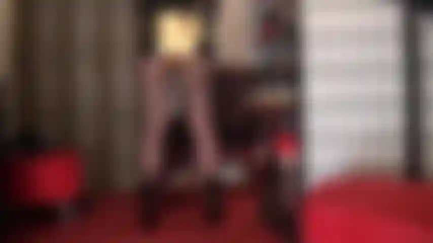 Herrin zeigt ihren hintern in glänzenden, goldmetallischen hotshorts, ihre kräftigen beine in hauchdünnen schwarzen strumpfhosen, gepaart mit kurzen schwarzen lackstiefeletten.