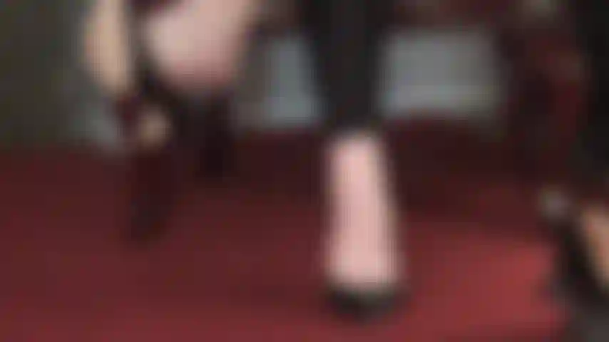 Die wohltuend mit nackten füßen baumelt – süße zehen, die aus lederpumps hervorschauen und den schuh gekonnt schwingen.