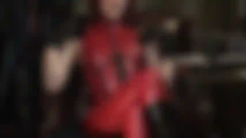 Die deinen sklavenschwanz mit einem blick in den frontreißverschluss eines glänzenden roten latex-fetisch-catsuits verrückt macht …