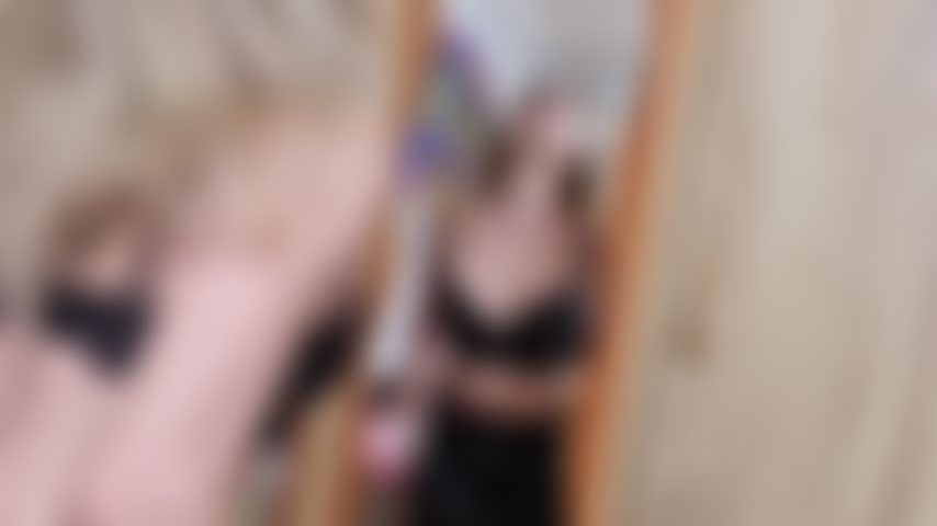 Eine versaute, freche blondine, die in leder gekleidet auf den spiegel spuckt und mit spucke spielt.