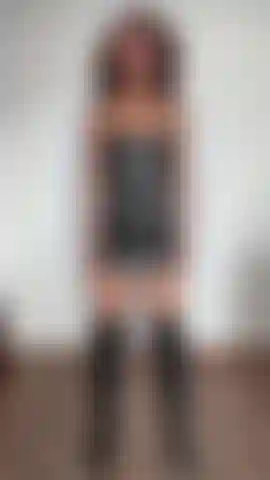 Mit angespannten bizeps und einem schwarzen lederkleid und stiefeln.