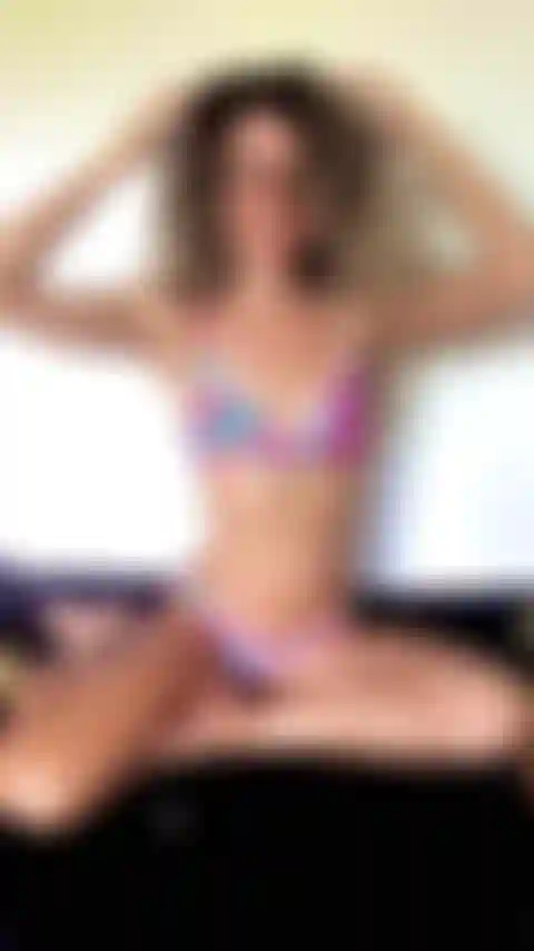 Posiere im bikini auf meinem bett und zeige meine bauchmuskeln.