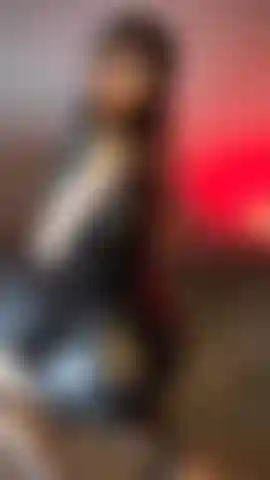 Ein sexy, tätowiertes baby in einem schwarzen lederkleid, netzstrümpfen und beim hinternversohlen.