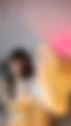 Ein baby in weißer unterwäsche und netzstrümpfen, streichle ihre füße und lächele verspielt in die kamera.